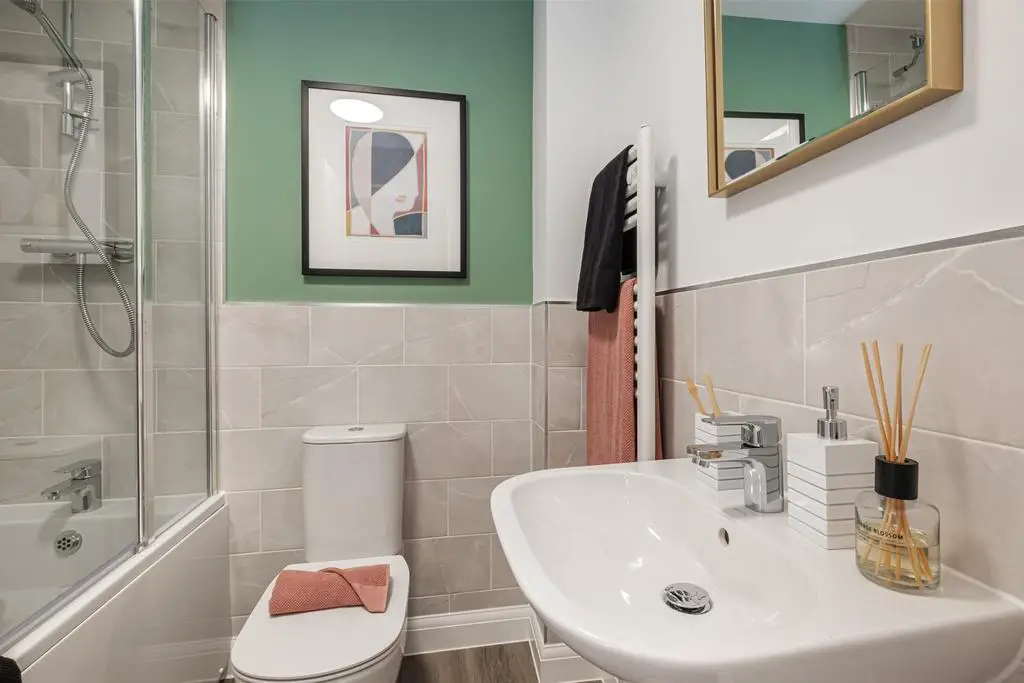 Bathroom with green painted wall above grey...