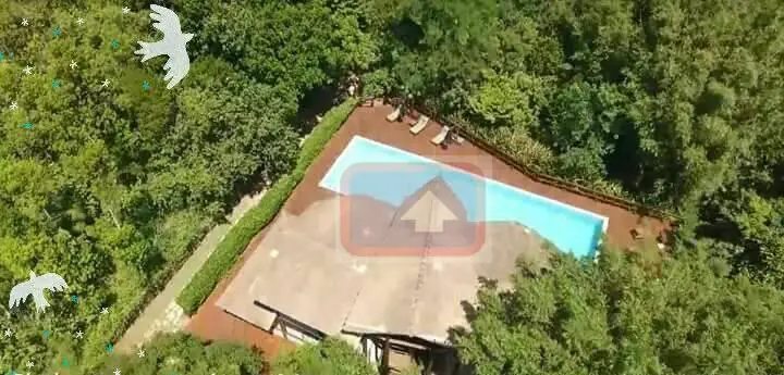 Vista aérea da piscina e de uma parte área de lazer do condomínio---