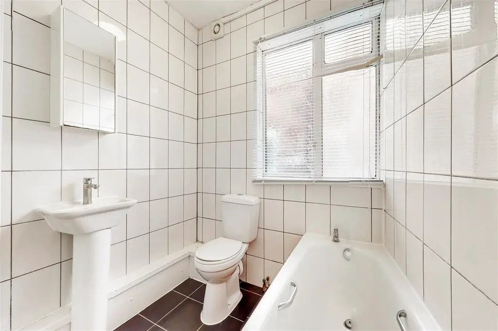 Fully tiled white bathroom combined W.C