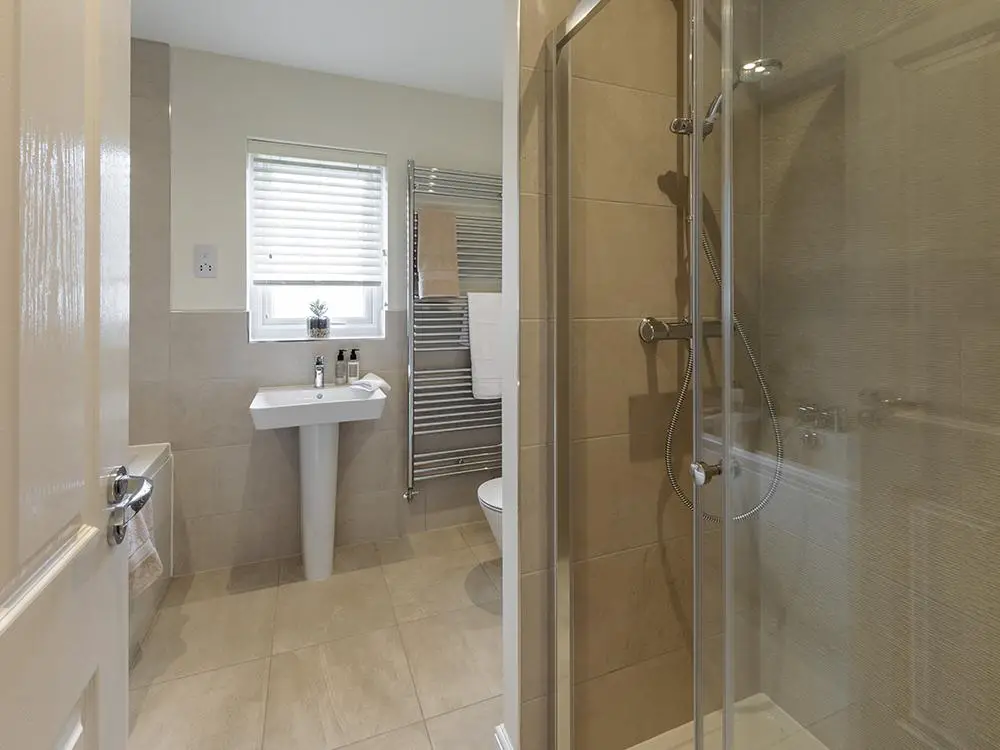 Extensively tiled family bathroom with separate...