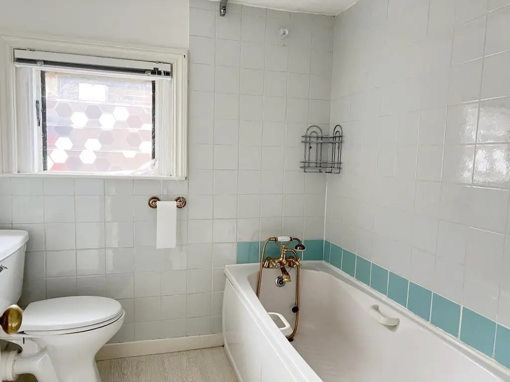 White bathroom suite with white tiled walls