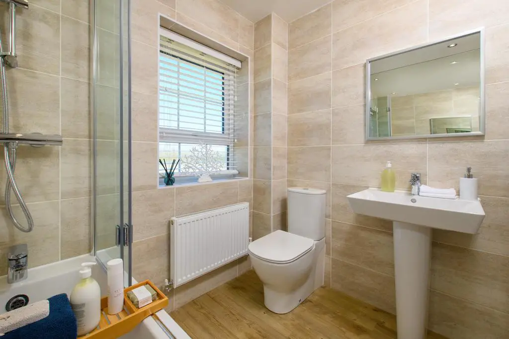 Family bathrom with shower over bath in...